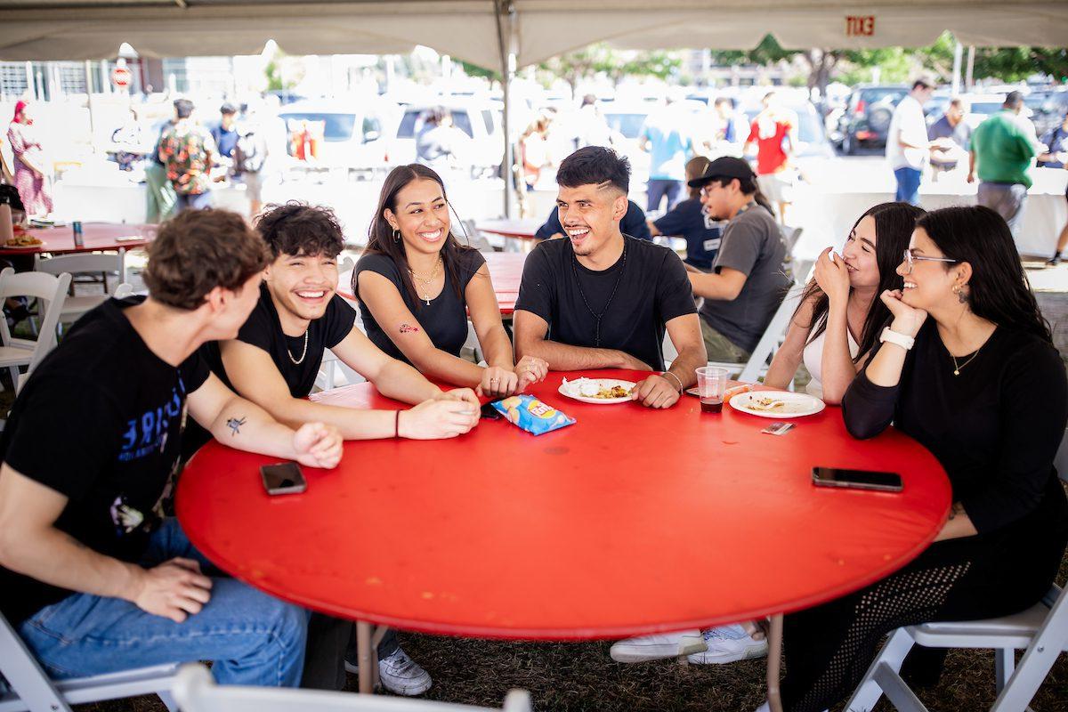 Students sitting around a table and laughing